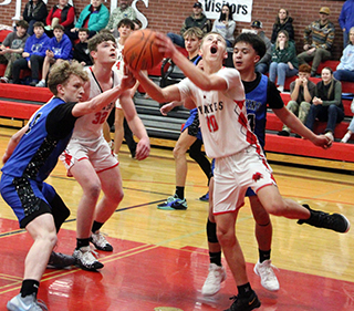 Phil Schwartz goes for a reverse lay-up against Orofino. Also shown is Nate Forsmann.