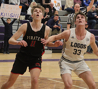 Briggs Rambo battles for a rebound against Logos. The badly sprained ankle he suffered at Kendrick kept him from being his usual self in the scoring column.
