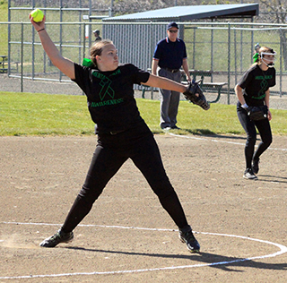 Kaylie Lockett pitching against Grangeville. The black with green lettering tops are part of Bailey Key’s Senior project.