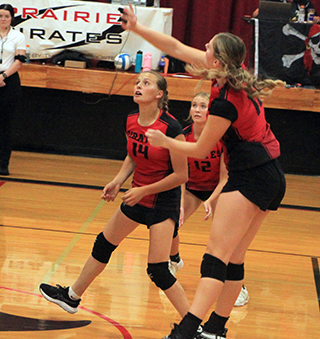 Kylie Schumacher spikes the ball against Potlatch. Also shown are Ellie Nuxoll and Avery Riener.