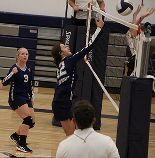 Savannah Perrin tips the ball over the net as Rachel Sonnen looks on. This was during the Patriots’ first win in the new Angelus Center gym.