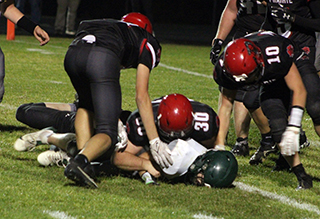 Jake Quintal has tackled a Potlatch ball carrier. At left in Briggs Rambo while at right is Chris Schumacher.