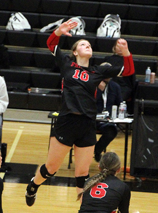 Kylie Schumacher goes for a spike against Oakley. Also shown is Tamden Pecarovich.