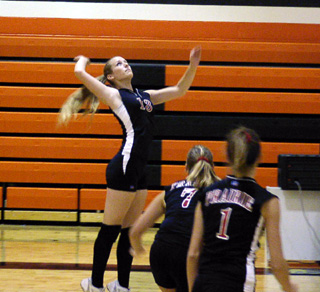 Kylie Uhlorn winds up for one of her team high 16 kills at Troy. Also shown are Tessica Nuxoll and Randi Schumacher.