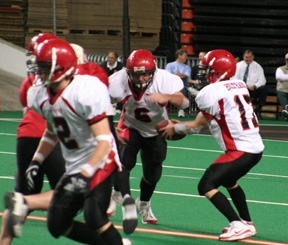 Kyle Holthaus hands off to Branden Waller. Conner Rieman is at left.