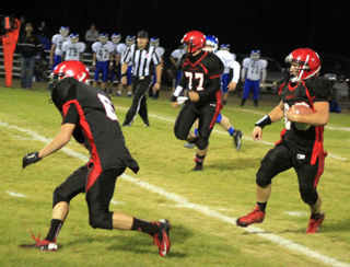 In a turnabout from the top photo, Luke Wemhoff, left, is about to make a block to enable Calvin Hinkelman to gain more yards. Also shown is Hunter Hasselstrom, 77.