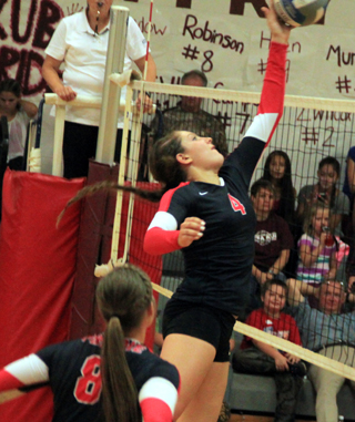 Shayla VonBargen goes lefty to tip the ball past Kamiahs blockers. Also shown is Hailey Danly, who made the set.