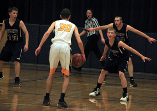 John Uhlenkott, Cody Wassmuth and David Wassmuth on defense at Logos.