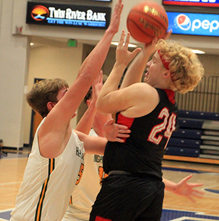 Noah Behler puts up a shot against a Shadle Park doubleteam at the Avista Holiday tournament at the LCSC Activity Center.