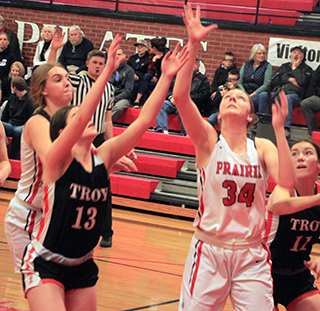 Kylie Schumacher looks to see if her shot goes in against Troy. At left is Alli Geis.