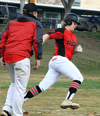 Noah Behler rounds first with Prairie's first hit of the new baseball season.