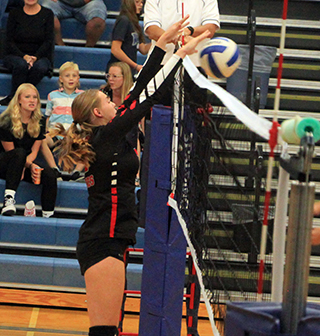 Alli Geis blocks a spike attempt at Genesee.