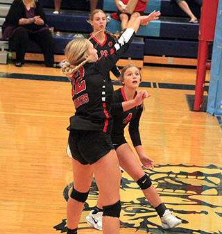 Taylor Riener spikes the ball at Lapwai. Also shown are Alli Geis and Lexi Schumacher.