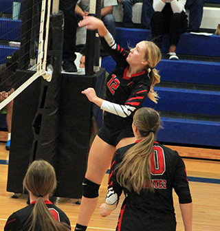 Taylor Riener spikes the ball at Orofino. Also shown are Sydney Shears and Kylie Schumacher.