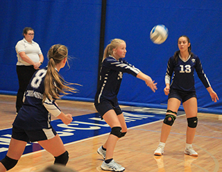 Catherine Seubert makes a pass against Timberline at District. Also shown are Noelle Chmelik and Raylie Warren.