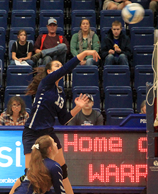 Raylie Warren spikes the ball. Also shown is Sarah Waters.