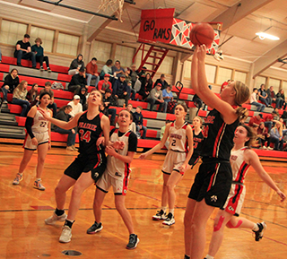 Alli Geis shots a lay-up at C.V. as Kylie Schumacher gets ready for a rebound. In the background is Erica Schlader.