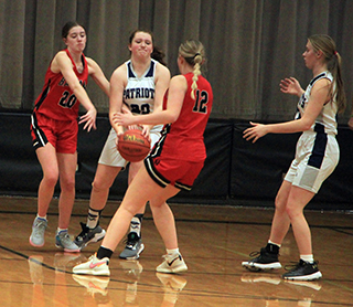 Miah Mager battles for a loose ball against the Clarkston JV. At right is Julia Wassmuth.