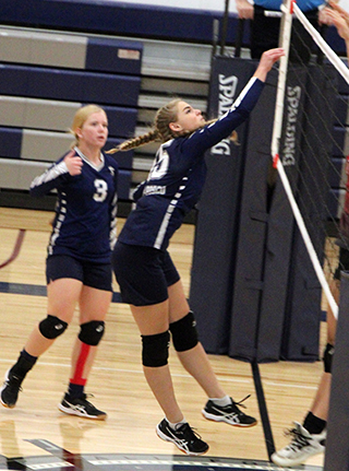 Presley Schoo spikes the ball against C.V. Also shown is Rachel Sonnen.